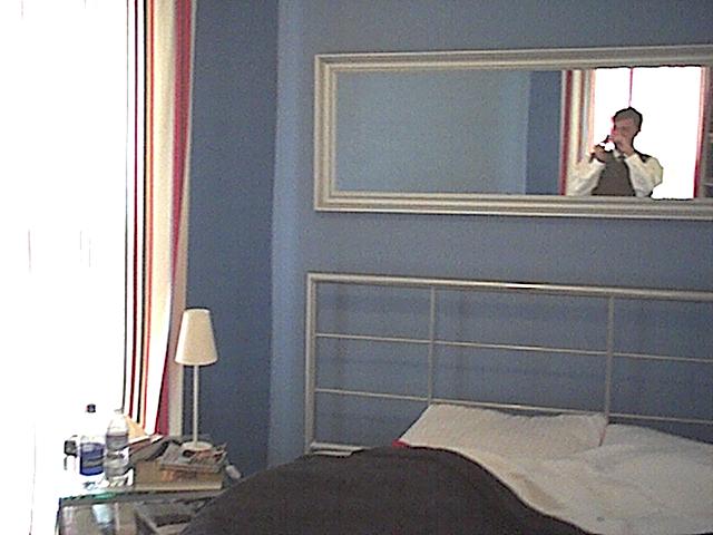 shot of blue room bed and mirror and nightstand